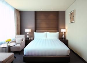 a hotel room with a bed and a chair at LOTTE City Hotel Gimpo Airport in Seoul