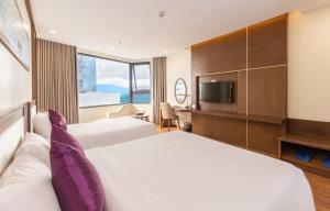 Postel nebo postele na pokoji v ubytování Rosamia Da Nang Hotel