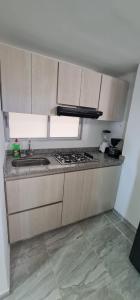 cocina con fregadero y fogones horno superior en Apartamento Entero Ibague - Parqueadero - Nogal en Ibagué