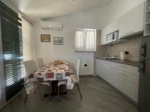 Residence4a-Appartamento Verde في رافني: مطبخ مع طاولة وكراسي في غرفة