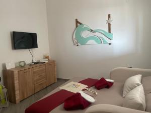a living room with a couch and a cross on the wall at Residence4a-Appartamento Verde in Ravni