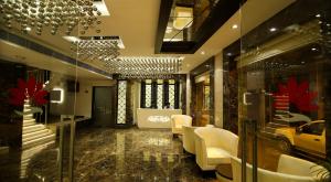 a lobby with white chairs and a chandelier at The Prime Balaji Deluxe @ New Delhi Railway Station in New Delhi