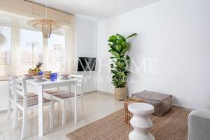 une salle à manger blanche avec une table et des chaises blanches dans l'établissement Apartamento Aman, à Jávea