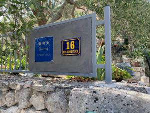 a sign sitting on top of a stone wall at Apartman Silna your new home with terrace and garden in Bobovišća