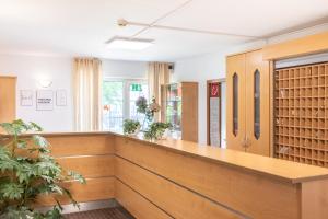 a waiting room with a wooden counter and plants at acora Düsseldorf Living the City in Düsseldorf