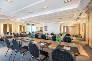 una sala conferenze con tavoli, sedie e lavagna di Hotel Elisenhof Mönchengladbach a Mönchengladbach