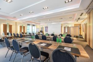 sala konferencyjna ze stołami, krzesłami i tablicą. w obiekcie Hotel Elisenhof Mönchengladbach w mieście Mönchengladbach