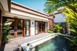 uma villa com uma piscina e uma casa em Tamantara em Ubud