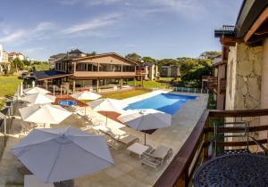 a balcony with umbrellas and a swimming pool at Ville Saint Germain Apart Hotel & Spa in Carilo