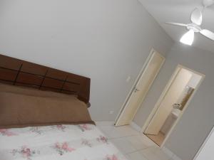 ein Schlafzimmer mit einem Bett und einem Deckenventilator in der Unterkunft Varanda Gourmet Beira-Mar in Praia Grande