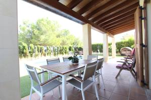 jadalnia ze stołem i krzesłami na patio w obiekcie Villa Puerto Adriano w mieście El Toro
