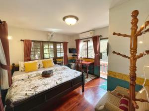 een slaapkamer met een bed en een bureau in een kamer bij Chomklong Experience in Pak Chong