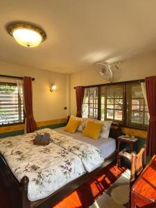 een slaapkamer met een bed met gele kussens bij Chomklong Experience in Pak Chong