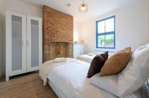 a bedroom with two beds and a brick wall at TempleTwenty5 by 360 Stays - Highly Rated Oxford Home with Parking in Oxford