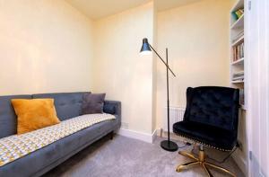 a living room with a blue couch and a black chair at TempleTwenty5 by 360 Stays - Highly Rated Oxford Home with Parking in Oxford