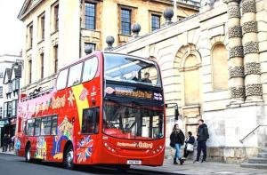 a red double decker bus parked in front of a building at TempleTwenty5 by 360 Stays - Highly Rated Oxford Home with Parking in Oxford