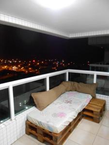 Bett auf einem Balkon mit Stadtblick in der Unterkunft Varanda Gourmet Beira-Mar in Praia Grande