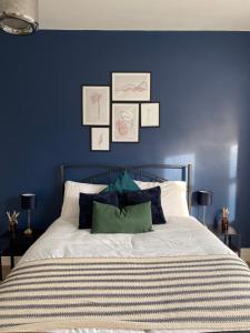 um quarto com paredes azuis e uma cama com almofadas em Stylish and Modern 3 bed Apartment with FREE PARKING, em Newcastle upon Tyne