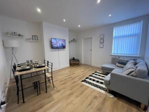 ein Wohnzimmer mit einem Sofa und einem Tisch in der Unterkunft Stylish and Modern 3 bed Apartment with FREE PARKING, in Newcastle upon Tyne