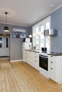 a large kitchen with white appliances and wooden floors at Old Charm Reykjavik Apartments in Reykjavík