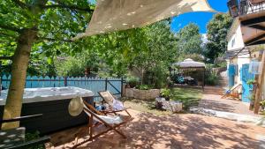 ogród z krzesłem i wanną na podwórku w obiekcie Spod Korit - Brgudac, Opatija with hot tub and free parking w mieście Brgudac