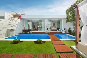 a swimming pool in the middle of a yard at The Daha Luxury Villas in Seminyak