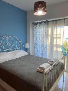 una camera da letto blu con un letto e una finestra di Karakonero view apartment a Città di Rodi Altre 11 foto