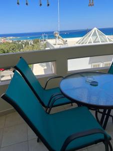 un tavolo e sedie su un balcone con vista sull'oceano di Karakonero view apartment a Città di Rodi
