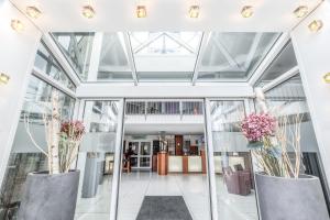 a conservatory with two large vases with flowers in it at Select Hotel Oberhausen in Oberhausen