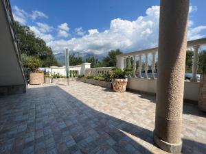 une terrasse avec une clôture et un pilier sur une maison dans l'établissement NEÐO Apartments Brda, à Tivat