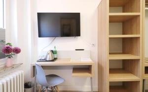 Zimmer mit einem Schreibtisch und einem TV an der Wand in der Unterkunft Kleine Möwe in Borkum