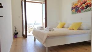 sypialnia z łóżkiem z żółtymi poduszkami i oknem w obiekcie Rooms by the sea Hvar - 5720 w Hvarze