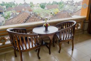 - Balcón con vistas, mesa y 2 sillas en Desak Putu Putra Home Stay, en Ubud