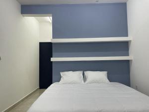 En eller flere senge i et værelse på Maan Hotel Apartment