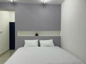 1 cama blanca con 2 almohadas en una habitación en Maan Hotel Apartment, en Ḩilf