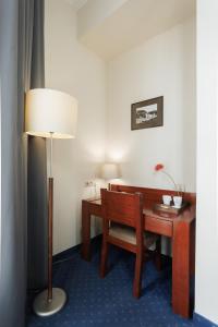 a room with a desk and a chair and a lamp at Hotel Piast Wrocław Centrum in Wrocław