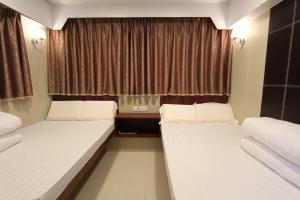 2 camas en una habitación pequeña con ventana en Prince Hotel, en Hong Kong