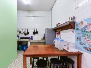 a kitchen with a wooden table and black chairs at SPOT ON 89872 Kuantan Backpackers in Kuantan