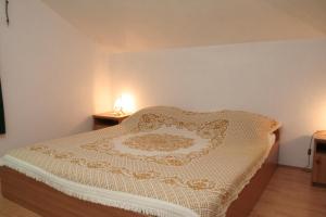 a bedroom with a bed with a white comforter on it at Apartments by the sea Lumbarda, Korcula - 4445 in Lumbarda