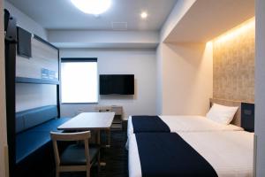 een hotelkamer met 2 bedden en een tafel bij Minn Kasai in Tokyo