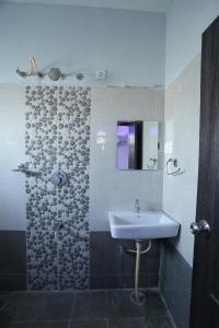a bathroom with a sink and a shower at Hotel RR International in Bangalore