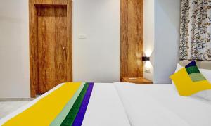 a bedroom with a white bed with a colorful blanket at Itsy By Treebo - Heraa International in Mumbai