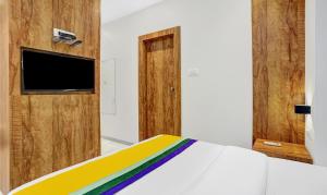 a bedroom with a bed and a flat screen tv at Itsy By Treebo - Heraa International in Mumbai