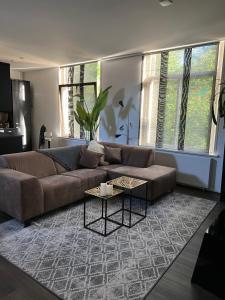sala de estar con sofá marrón y mesa en Canal apartment at historic CityCenter Amersfoort, en Amersfoort