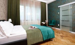 une chambre d'hôtel avec un lit et une chaise dans l'établissement Grand Phillip Cismigiu Park Downtown Bucharest, à Bucarest