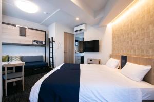 a hotel room with a large bed and a desk at Minn Kasai in Tokyo