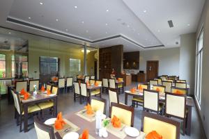 une salle à manger avec des tables et des chaises dans un restaurant dans l'établissement The Aurum Subrahmanya, à Subrahmanya