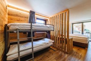 a bunk bed in a room with wooden floors at Hotel Steinbock in Livigno