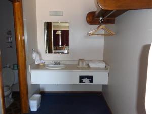 a bathroom with a sink and a mirror at National 9 Inn in Garden City