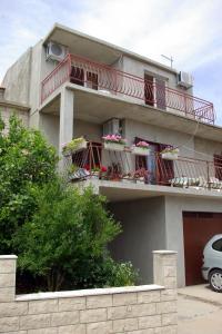 un edificio con un balcón con flores. en Apartments by the sea Brna, Korcula - 4333, en Brna